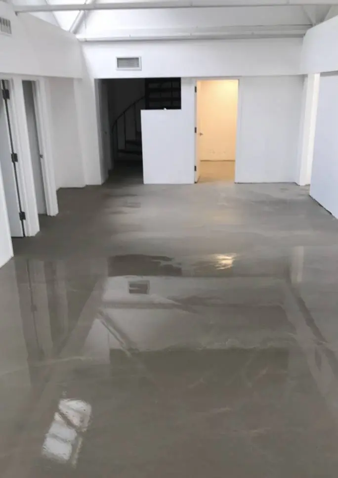 A flooded room with a door open and the floor in the middle of it.