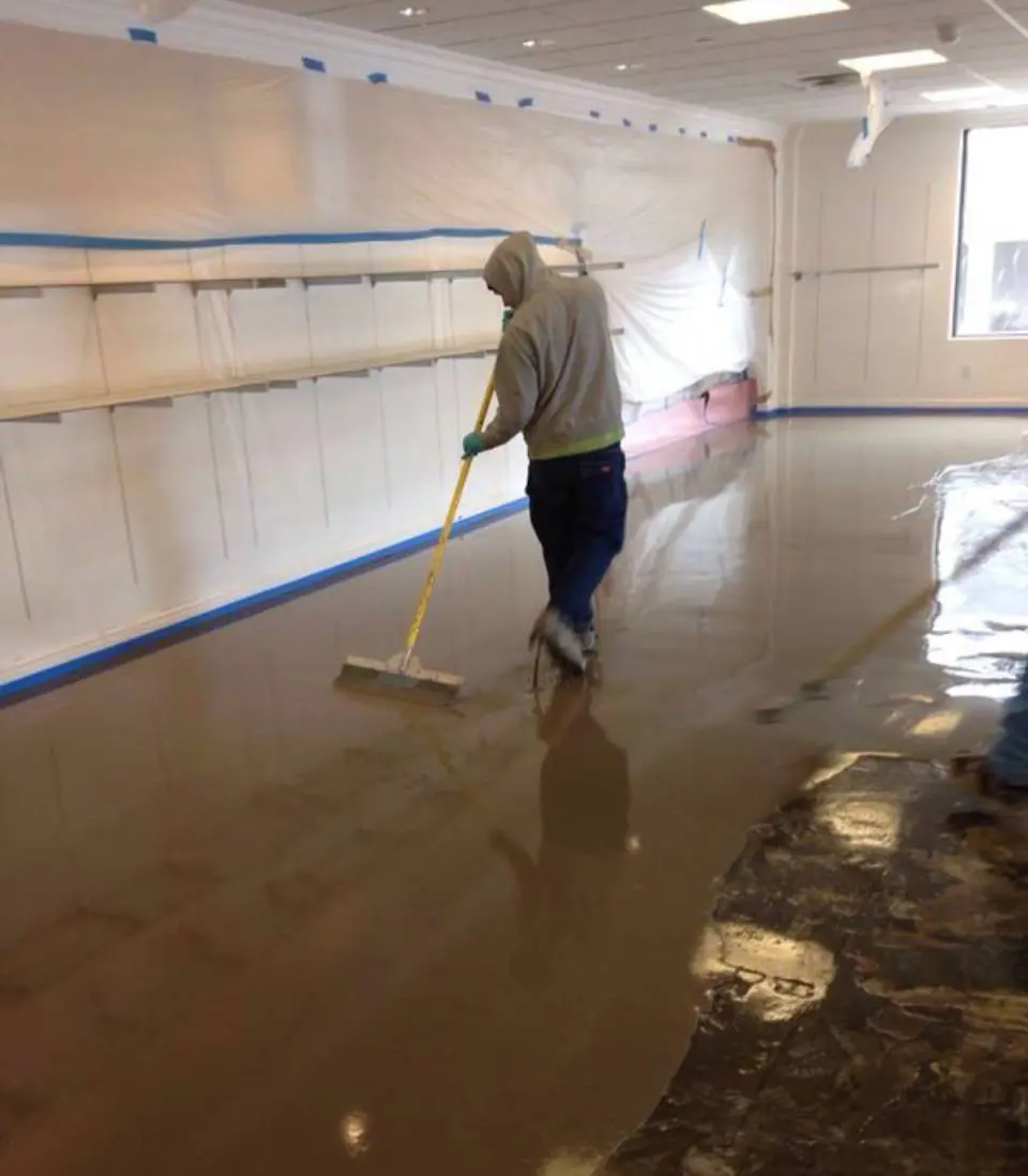 A man is cleaning the floor of an indoor arena.