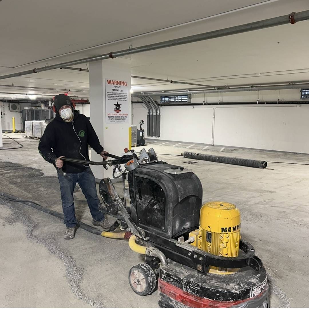 A man standing next to a machine in an empty parking lot.