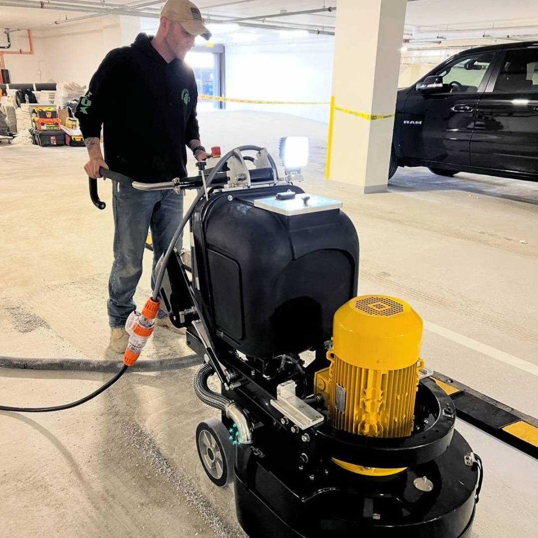 A man is using an electric floor scrubber.