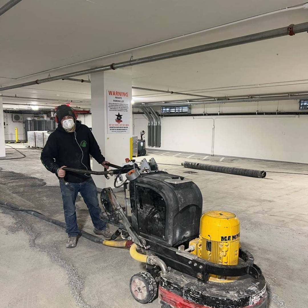 A man standing next to a machine in an empty building.