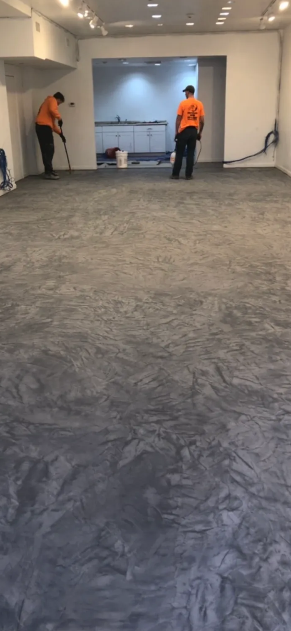 A person standing on top of a gray carpet.